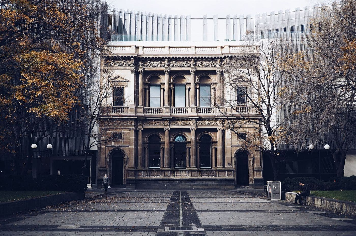 A historic university building behind autumn trees