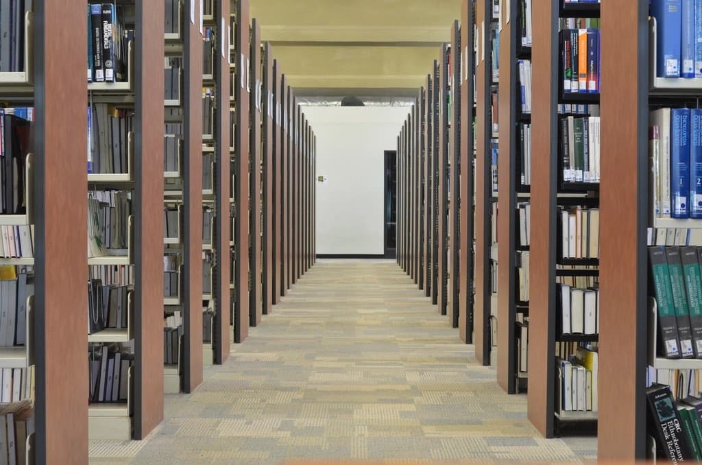 A long aisle between library bookshelves